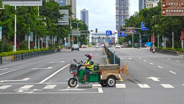 Seorang pekerja sanitasi melewati persimpangan di tengah tindakan penguncian untuk mengekang wabah penyakit coronavirus (COVID-19) di Sanya, provinsi Hainan, China, Sabtu (6/8/2022). (cnsphoto via REUTERS)