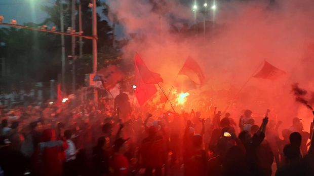 Massa buruh yang demo tinggalkan gedung DPR sambil menyalakan flare, Rabu (10/8/2022) pukul 18.07 WIB.