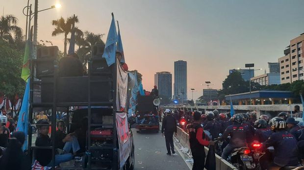 Massa buruh yang demo tinggalkan gedung DPR sambil menyalakan flare, Rabu (10/8/2022) pukul 18.07 WIB.