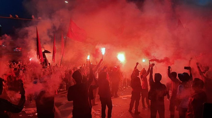 Massa buruh yang demo tinggalkan gedung DPR sambil menyalakan flare, Rabu (10/8/2022) pukul 18.07 WIB.