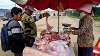 Dua orang pembeli memilih daging buaya yang dijual pedagang kaki lima. Mengonsumsi daging buaya di Kamboja sama halnya seperti daging ayam, sapi maupun babi yang diolah sebagai lauk maupun cemilan.