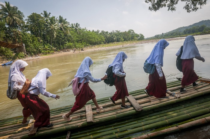 SISWA MENYEBERANGI SUNGAI DENGAN RAKIT BAMBU Siswa bersama orang tanya menunggu rakit bambu untuk menyeberangi sungai Ciberang di Desa Haurgajrug, Lebak, Banten, Selasa (9/8/2022). Putusnya akses jembatan gantung di desa tersebut mengakibatkan siswa terpaksa menyeberangi sungai setiap harinya menggunakan rakit dari bambu sehingga membahayakan keselamatan mereka. ANTARA FOTO/Muhammad Bagus Khoirunas/foc.