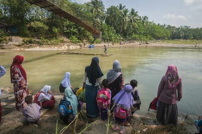 SISWA MENYEBERANGI SUNGAI DENGAN RAKIT BAMBU Siswa bersama orang tanya menunggu rakit bambu untuk menyeberangi sungai Ciberang di Desa Haurgajrug, Lebak, Banten, Selasa (9/8/2022). Putusnya akses jembatan gantung di desa tersebut mengakibatkan siswa terpaksa menyeberangi sungai setiap harinya menggunakan rakit dari bambu sehingga membahayakan keselamatan mereka. ANTARA FOTO/Muhammad Bagus Khoirunas/foc.