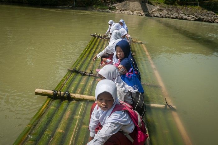 SISWA MENYEBERANGI SUNGAI DENGAN RAKIT BAMBU Siswa bersama orang tanya menunggu rakit bambu untuk menyeberangi sungai Ciberang di Desa Haurgajrug, Lebak, Banten, Selasa (9/8/2022). Putusnya akses jembatan gantung di desa tersebut mengakibatkan siswa terpaksa menyeberangi sungai setiap harinya menggunakan rakit dari bambu sehingga membahayakan keselamatan mereka. ANTARA FOTO/Muhammad Bagus Khoirunas/foc.