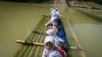 Anak SD ini menggunakan rakit menyeberangi sungai untuk mencapai sekolah di Desa Haurgajrug, Lebak, Banten, Selasa (9/8/2022)