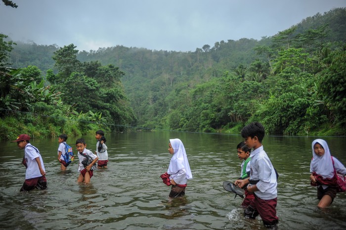 SISWA SEBERANGI SUNGAI UNTUK SEKOLAH Warga menggendong anaknya untuk menyeberangi Sungai Ciujung di Desa Sukaluyu, Cikadu, Cianjur Selatan, Kabupaten Cianjur, Jawa Barat, Rabu (10/8/2022). Sejak tahun 2018, ratusan siswa dari Desa Karyabakti terpaksa harus menerjang Sungai Ciujung untuk sekolah di SDN Padawaras Desa Sukaluyu karena tidak ada akses jalan lain untuk menuju sekolah mereka. ANTARA FOTO/Raisan Al Farisi/YU