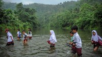 Siswa SD menyeberangi Sungai Ciujung untuk menuju sekolah di Desa Sukaluyu, Cikadu, Cianjur Selatan, Kabupaten Cianjur, Jawa Barat, Rabu (10/8/2022).