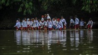 Bocah SD ini mengenakan seragam menuju sekolahnya dengan menerobos sungai. Kondisi memprihatinkan ini dilakukan sejak 2018 lalu.