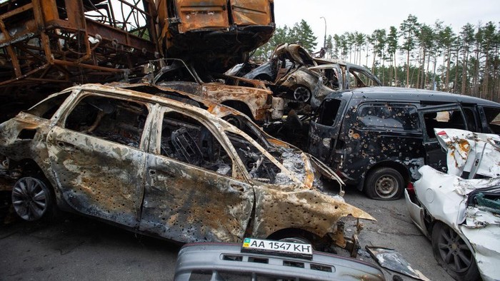 IRPIN, UKRAINE - APRIL 20: Cars shot up and burnt during the month-long Russian military presence are piled alongside the road in the suburb northwest of Kyiv of Irpin, Ukraine, on April 20, 2022. Russian forces that invaded Ukraine on three fronts in late February were defeated in their efforts to cut-off and encircle the capital Kyiv, forcing a withdrawal which left behind hundreds of dead Ukrainian civilians on the streets and in yards, and in hastily dug temporary graves, making Bucha, Irpin and other suburbs now symbols of Russian military cruelties and reason for war crimes accusations. (Photo by Scott Peterson/Getty Images)