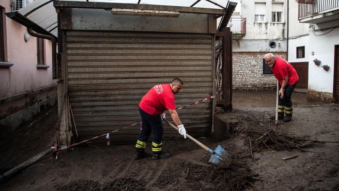 MONTEFORTE IRPINO, ITALY - AUGUST 10: People sweep in a restaurant which was hit with mud and debris following severe flooding on August 10, 2022 in Monteforte Irpino, Italy. On the evening of 9 August 2022 a mud and debris flow hit the Municipality of Monteforte Irpino due to a sudden water bomb due to sudden and abundant rains. Fortunately, the flood did not cause victims, but forced: firefighters, workers of the mountain community of Partenio, civil protection volunteers and municipal technicians, to work until the afternoon of 10 August, to clear the streets of mud to prevent new damage due to the weather alert scheduled for today, in the area already affected by a landslide that took place in 2020. (Photo by Ivan Romano/Getty Images)