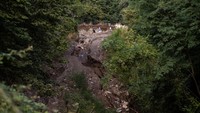 Pemandangan lumpur dan puing-puing di bagian hulu pascabanjir. 