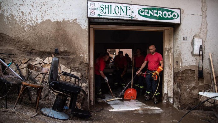 MONTEFORTE IRPINO, ITALY - AUGUST 10: People sweep in a restaurant which was hit with mud and debris following severe flooding on August 10, 2022 in Monteforte Irpino, Italy. On the evening of 9 August 2022 a mud and debris flow hit the Municipality of Monteforte Irpino due to a sudden water bomb due to sudden and abundant rains. Fortunately, the flood did not cause victims, but forced: firefighters, workers of the mountain community of Partenio, civil protection volunteers and municipal technicians, to work until the afternoon of 10 August, to clear the streets of mud to prevent new damage due to the weather alert scheduled for today, in the area already affected by a landslide that took place in 2020. (Photo by Ivan Romano/Getty Images)