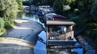 Penampakan rumah-rumah apung yang sebelumnya berada di atas air, kini kandas hingga menyentuh dasar sungai.
