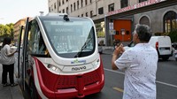 Warga memotret kendaraan lucu ini. Mobil tanpa sopir tersebut dapat melaju mencapai kecepatan maksimum 25 km per jam. Penggunaan baterei mobil rata-rata 9 jam.