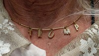 Tampak pria tersebut memakai kalung bertuliskan Trump.