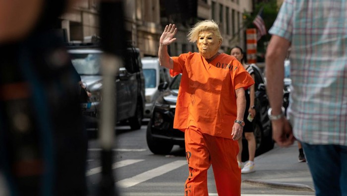 Ketika Warga Sindir Donald Trump dengan Baju Tahanan A former U.S. President Donald Trump supporter wears a Trump necklace at Trump Tower two days after Trump said that FBI agents raided his Mar-a-Lago Palm Beach home, in New York City, U.S., August 10, 2022. REUTERS/David 'Dee' Delgado