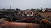 Besi dan material keras terlihat melengkung terbakar api. Selama berhari-hari kebakaran itu menimbulkan asap tebal hitam yang membubung tinggi ke udara.