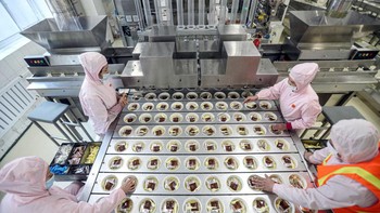 Proses peletakan bumbu masih dilakukan oleh tangan manusia. Foto: Getty Images