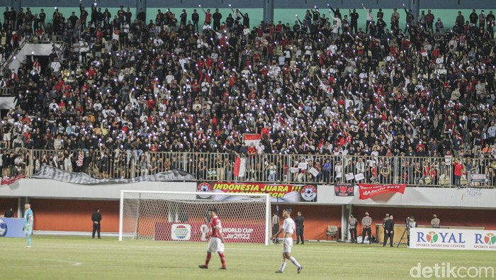 Mereka hadir mendukung timnas Indonesia U16 lengkap dengan atributnya. Ada yang membawa poster berisi tulisan, menempelkan stiker pada pipi, mengenakan baju timnas, hingga membentang bendera merah putih.