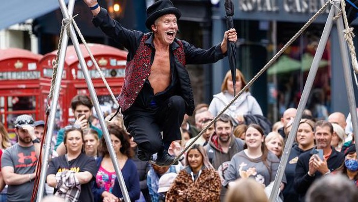 EDINBURGH, SCOTLAND - AUGUST 10: A street entertainer performs on Edinburghs Royal Mile during the citys Festival Fringe on August 10, 2022 in Edinburgh, Scotland. Thousands of performers from across the world are in the Scottish Capital for the worlds biggest arts festival, Edinburgh Festival Fringe hosts more than 3,000 shows from 58 countries marking the events 75th anniversary. (Photo by Jeff J Mitchell/Getty Images)