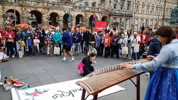 Ribuan Seniman Ngumpul di Skotlandia Ramaikan Festival Seni Terbesar di Dunia EDINBURGH, SCOTLAND - AUGUST 10: A street entertainer performs on Edinburgh's Royal Mile during the city's Festival Fringe on August 10, 2022 in Edinburgh, Scotland. Thousands of performers from across the world are in the Scottish Capital for the world's biggest arts festival, Edinburgh Festival Fringe hosts more than 3,000 shows from 58 countries marking the events 75th anniversary. (Photo by Jeff J Mitchell/Getty Images)