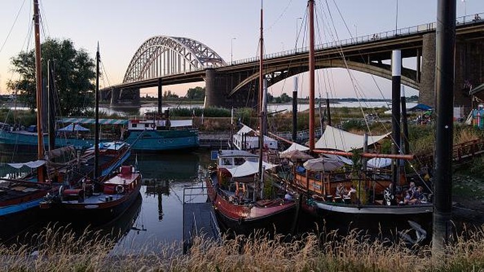 NIJMEGEN, NETHERLANDS - AUGUST 10: People enjoy the evening on the banks of the Waal river on August 10, 2022 in Nijmegen, Netherlands. The ongoing drought and the recurring heat waves have cut operation capacities by half along the lower Rhine from Rotterdam to Germany, an important coal transport route destined to steelmakers and power producers. (Photo by Pierre Crom/Getty Images)