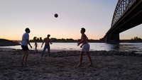 Air yang menyusut hingga dasar sungai yang mengering dimanfaatkan warga sebagai tempat rekreasi bak di pantai.  
