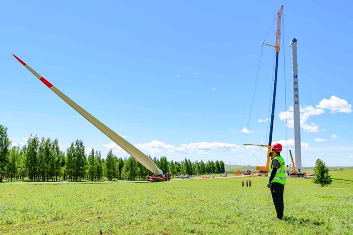XING'AN LEAGUE, CHINA - AUGUST 11, 2022 - Construction personnel work at the construction site of a 200,000-kilowatt wind power project in Hinggan League, Inner Mongolia, China, Aug 11, 2022. The project generates 590 million kilowatt-hours of electricity annually and cuts 550,000 tons of carbon dioxide annually. The project uses a unit with a single capacity of 6.25 MW and a blade length of 182 meters to generate electricity, which is the largest single capacity and longest blade wind turbine in the world. (Photo credit should read CFOTO/Future Publishing via Getty Images)