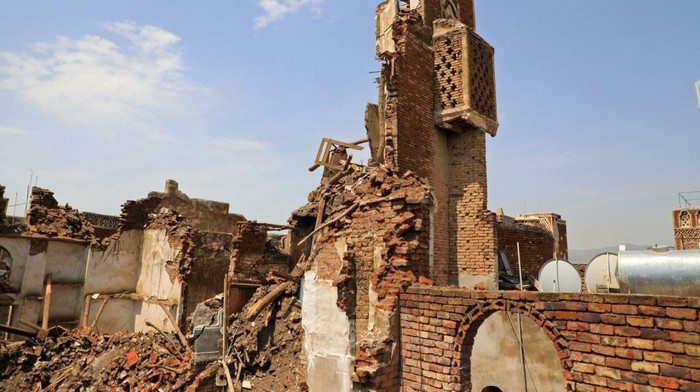 People inspect a collapsed UNESCO-listed building in the old city of the Yemeni capital Sanaa on August 10, 2022 following heavy rains. (Photo by MOHAMMED HUWAIS / AFP) (Photo by MOHAMMED HUWAIS/AFP via Getty Images)