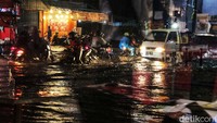 Pengendara melintasi genangan air di Jalan Haji Nawi Raya, tepatnya di pertigaan ITC Fatmawati, Jakarta Selatan, Jumat (12/8/2022).