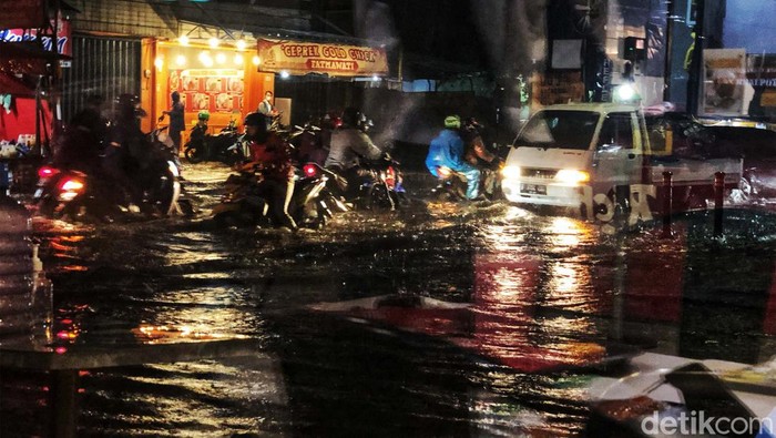 Pengendara melintasi genangan air di jalan Haji Nawi Raya, tepatnya di pertigaan ITC Fatmawati, Jakarta Selatan, Jumat (12/8/2022). Genangan tersebut setelah hujan turun sekitar 30 menit dengan intensitas tinggi. Genangan sekitar 40cm. Foto diambil pukul 19.00 WIB.