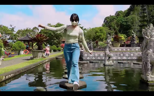 Pemberhentian Dita Karang selanjutnya adalah objek wisata Tirta Gangga, yang merupakan bekas istana kerajaan Bali. Wanita keturunan bangsawan itu memakai kacamata hitam di tengah teriknya matahari. Foto: dok. YouTube Secret Number