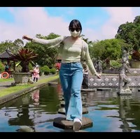 Pemberhentian Dita Karang selanjutnya adalah objek wisata Tirta Gangga, yang merupakan bekas istana kerajaan Bali. Wanita keturunan bangsawan itu memakai kacamata hitam di tengah teriknya matahari. Foto: dok. YouTube Secret Number