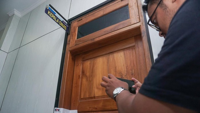 Seorang wartawan memotret pintu salah satu ruangan Dinas Kominfo Kabupaten Pemalang yang telah disegel oleh KPK di Pemda Kabupaten Pemalang, Jawa Tengah, Kamis (11/8/2022). Penyegelan ruangan tersebut terkait adanya infomasi tentang operasi tangkap tangan (OTT) Bupati Pemalang yang dilakukan KPK pada Kamis (11/8). ANTARA FOTO/Harviyan Perdana Putra/tom.
