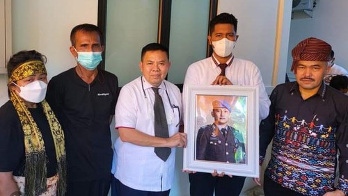 Kuasa hukum Brigadir J, Martin Lukas Simanjuntak memegang foto Brigadir J, didampingi oleh kuasa hukum lain, dan keluarga Brigadir J.