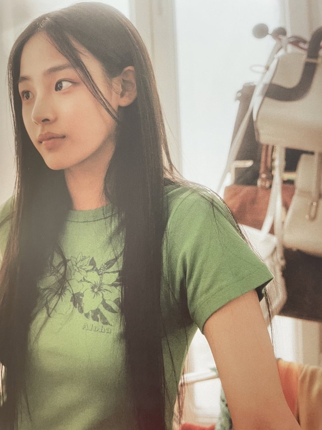 “aduh mbak minji ngingetin aku sama cinta AADC pas liat foto ini kaosan rambut panjang makeup natural,” tulis netizen setelah mengomentari foto Minji NewJeans. Foto: dok. ADOR, Twitter