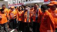 Saiq Iqbal (tengah) memimpin kader Partai Buruh menuju KPU. Dia terlihat mengenakan kaos berwarna oranye dengan lambang Partai Buruh di sisi tengah.