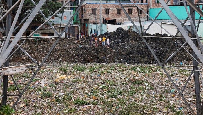 Penampakan Kanal di Bangladesh yang Jadi Dataran Gegara Sampah A boy walks over a land of waste in Dhaka, Bangladesh, August 11, 2022. REUTERS/Mohammad Ponir Hossain