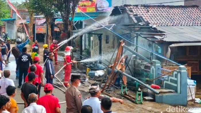 Petugas melakukan pembasahan pertamini yang terbakar di Banyuwangi Petugas melakukan pembasahan pertamini yang terbakar di Banyuwangi