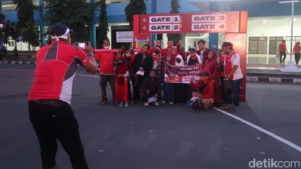 Dengan mengenakan pakaian serba merah, pendukung Timnas ini ada sibuk berswafoto di depan tulisan stadion Maguwoharjo. Sedangkan beberapa orang lagi tampak sibuk membeli merchandise Timnas di stand depan stadion.
