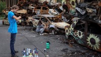 Lukisan bunga matahari ini membuat bangkai-bangkai mobil yang suram ini jadi lebih cerah.  