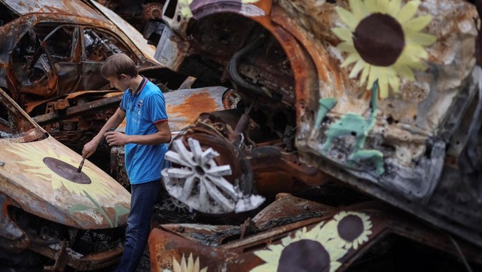 Seniman Ukraina Ubah Mobil Rongsok Jadi 'Ladang Bunga Matahari' A Ukrainian artist Viacheslav Rybka paints a car destroyed during Russia's attack on Ukraine and then collected from different places in the town of Irpin in Kyiv region, Ukraine August 10, 2022. REUTERS/Gleb Garanich TPX IMAGES OF THE DAY