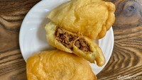 Panada berukuran besar dan tebal. Ketika dibelahnya, isian cakalang suwir berbumbu pedas terlihat padat sekali. Harganya dibanderol Rp 15.000 per buah. Foto: detikFood/Yenny Mustika Sari
