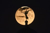 A Supermoon rises in the night sky in Beijing, Thursday, Aug. 11, 2022. (AP Photo/Ng Han Guan)
