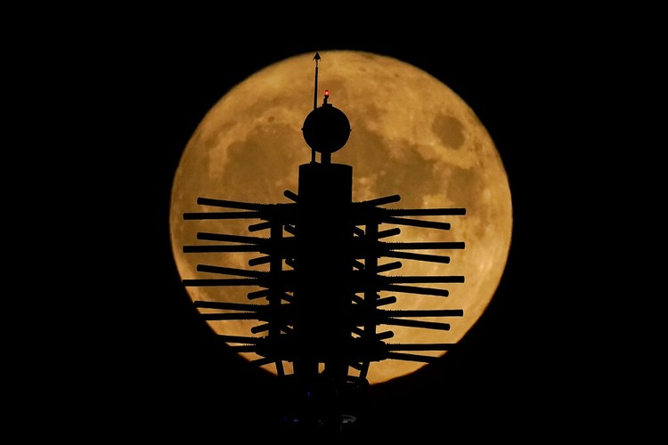 A Supermoon rises in the night sky in Beijing, Thursday, Aug. 11, 2022. (AP Photo/Ng Han Guan)