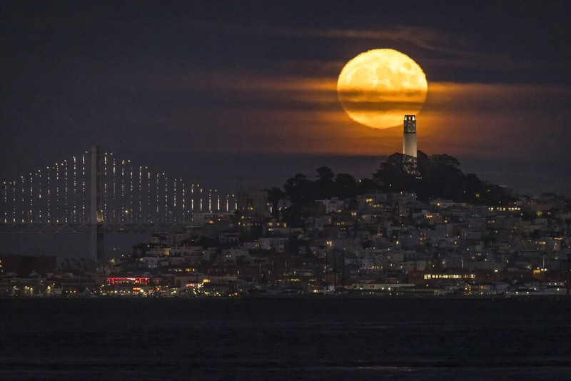A Supermoon rises in the night sky in Beijing, Thursday, Aug. 11, 2022. (AP Photo/Ng Han Guan)