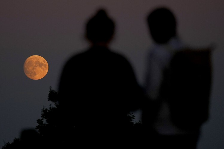A Supermoon rises in the night sky in Beijing, Thursday, Aug. 11, 2022. (AP Photo/Ng Han Guan)