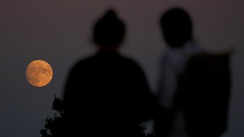 Saat peristiwa terjadi, posisi Bulan berada di titik paling dekat dengan Bumi sehingga muncul fenomena Bulan purnama. Foto: AP/Ng Han Guan