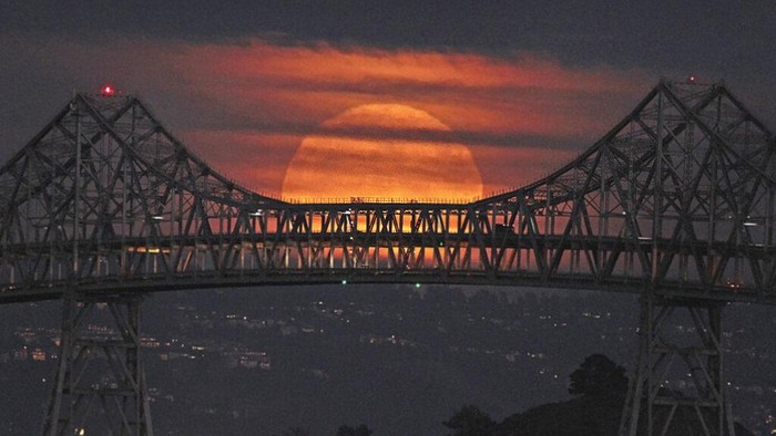 A Supermoon rises in the night sky in Beijing, Thursday, Aug. 11, 2022. (AP Photo/Ng Han Guan)