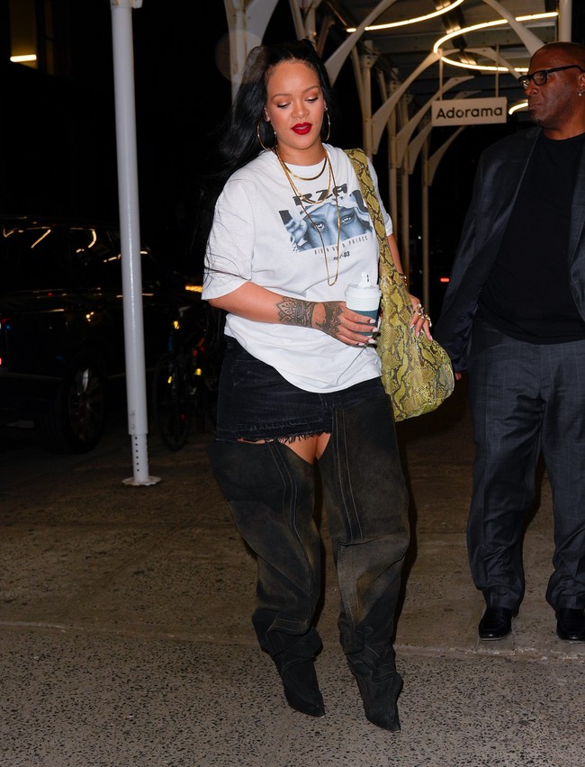 Big is beautiful. Ada saatnya Rihanna ingin berbusana tertutup. Pilihannya pun jatuh pada oversized graphic shirt, rok mini, dan high-knee boots. (Foto: GC Images/Gotham)